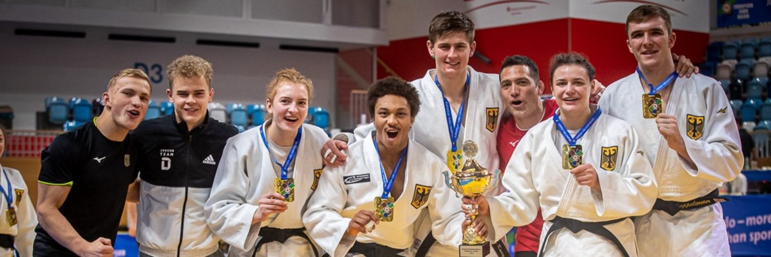 Judokas der U23 halten ihre Medaillen und Pokal in die Kamera.
