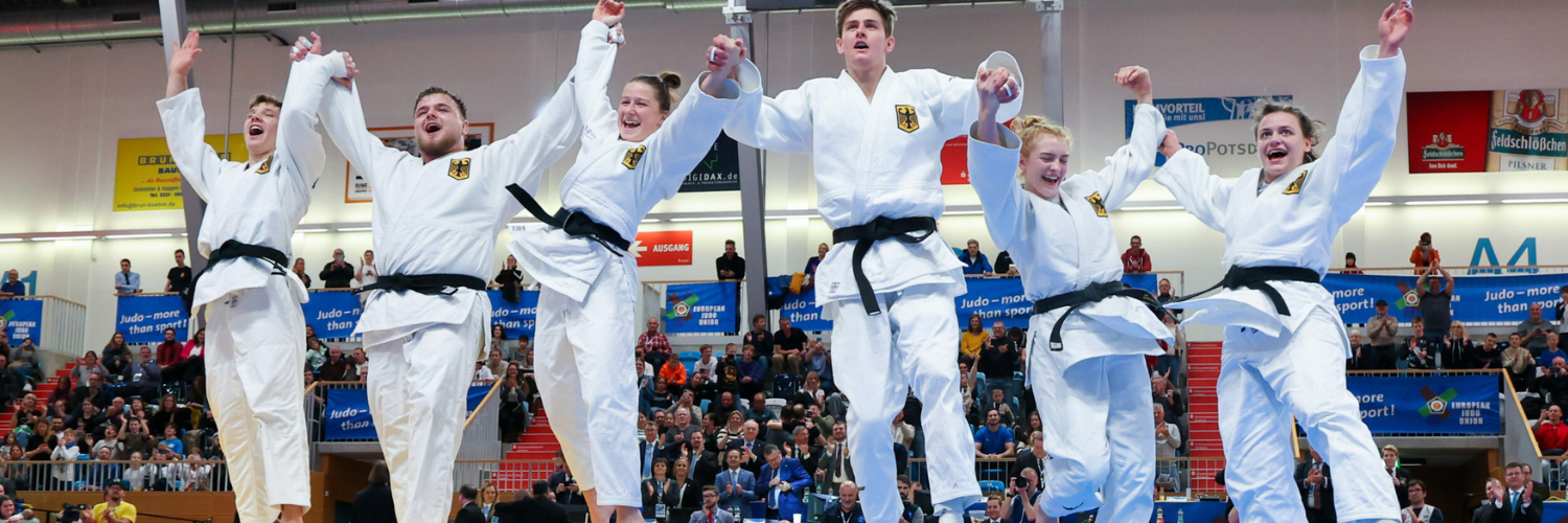 Judokas der Deutschen Nationalmannschaft, die in die Luft springen und jubeln.