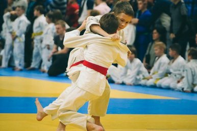 Zwei junge Judoka mit rotem Guertel waehrend eines Wettkampfes.